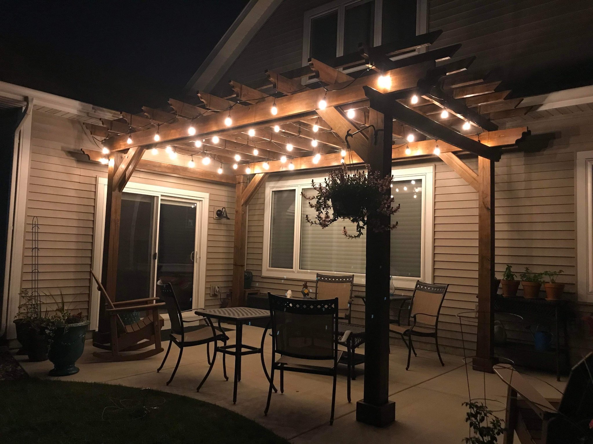 Warm cedar pergola with red cushion seating at sunset